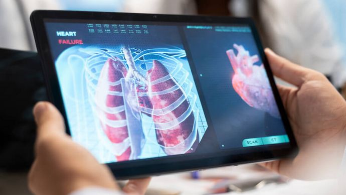 Arzt und Pflegekraft betrachten am Tablet eine Aufnahme eines Herzens