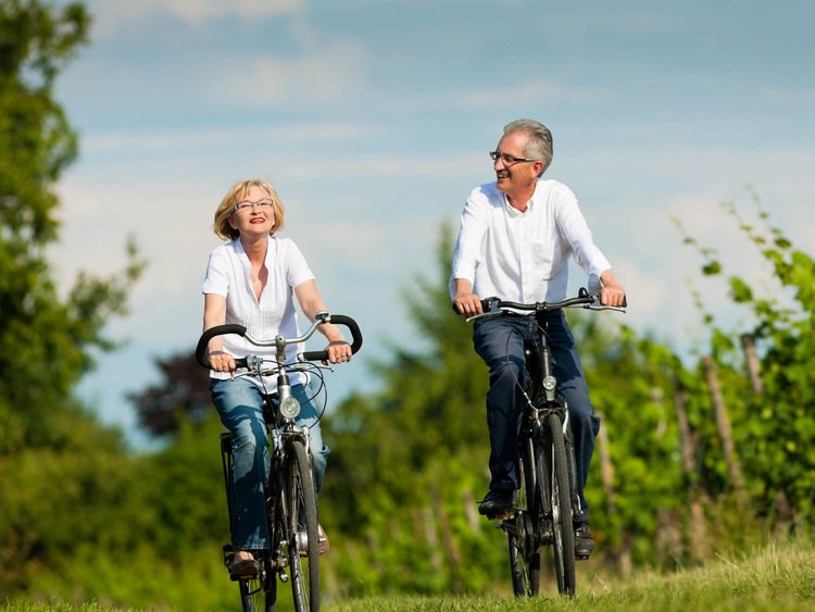 Mittelaltes Ehepaar fährt gemeinsam Fahrrad im Sommer